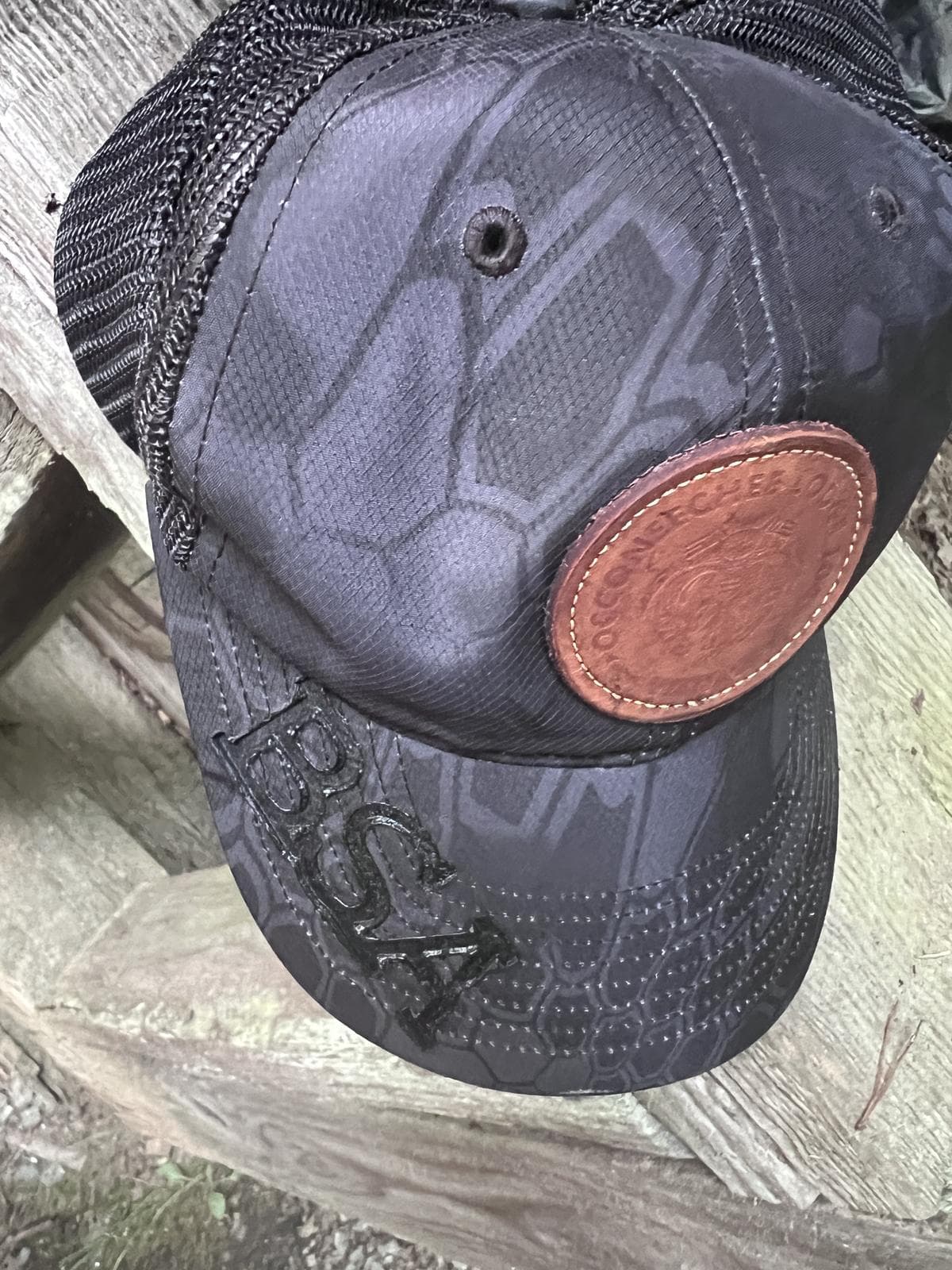 Close-up of a BSA-branded cap resting on a wooden bench
